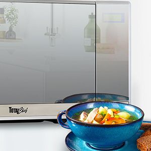 Closeup of Total Chef 1100 watt 1.3 cubic foot microwave with a blue stoneware bowl of soup