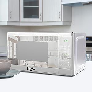 Compact 1100W stainless steel Total Chef microwave on a white counter in an elegant white kitchen