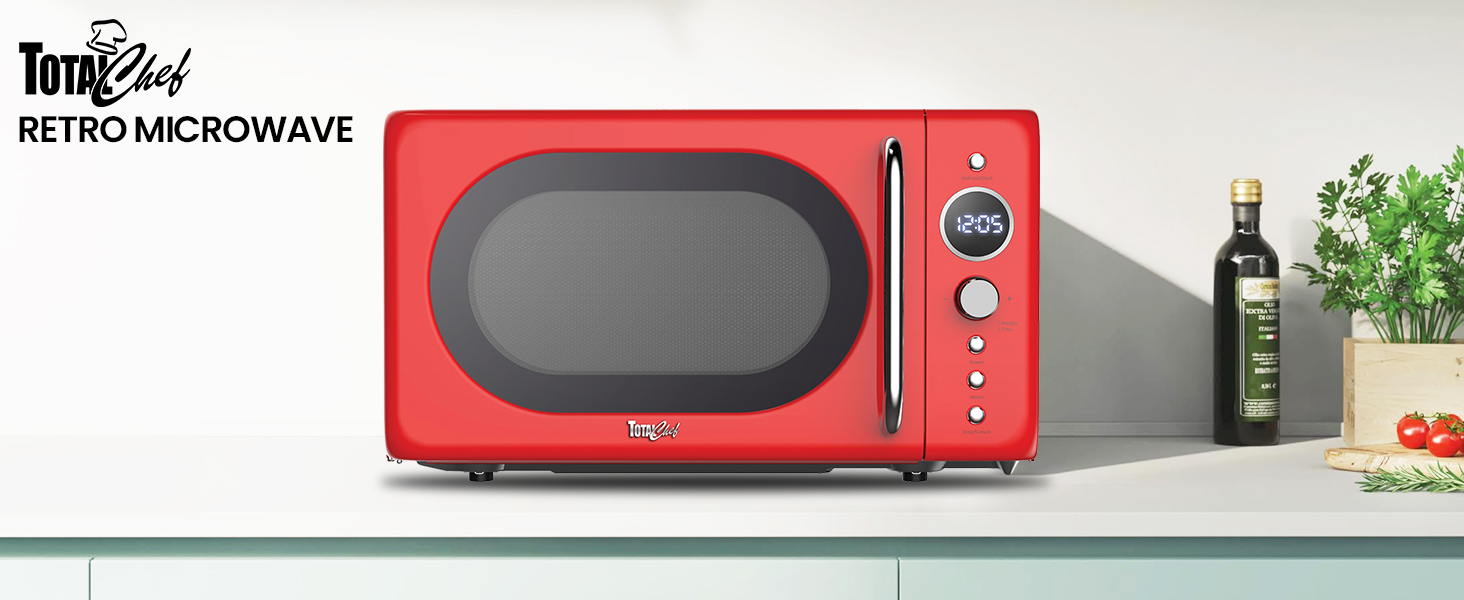 Red retro-style microwave oven with rounded edges, large viewing window, and control panel. Displayed on white countertop with kitchen items in background.