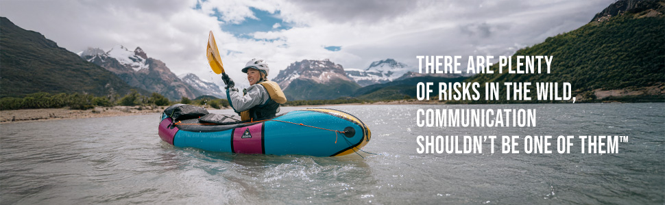 Woman packrafting in front of mountains