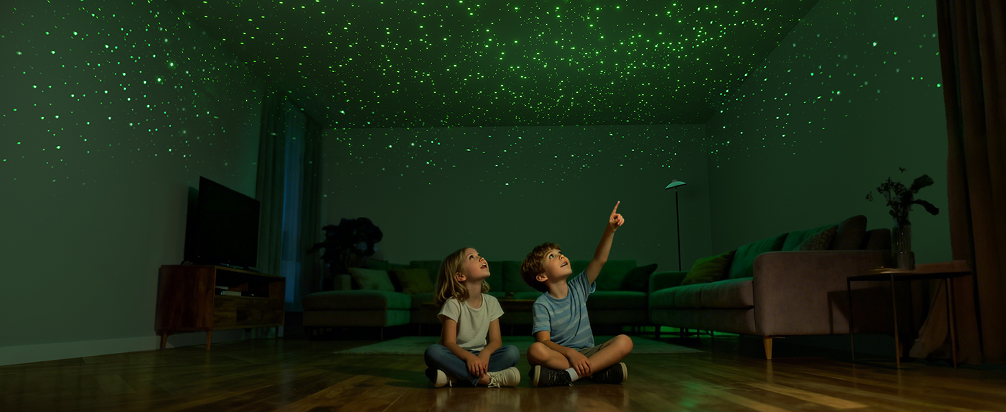Dark room with projected star-like lights on ceiling, showing a scene of people pointing upwards in an immersive space environment.
